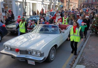 Santa rides up Main Street Nantucket in a classic car